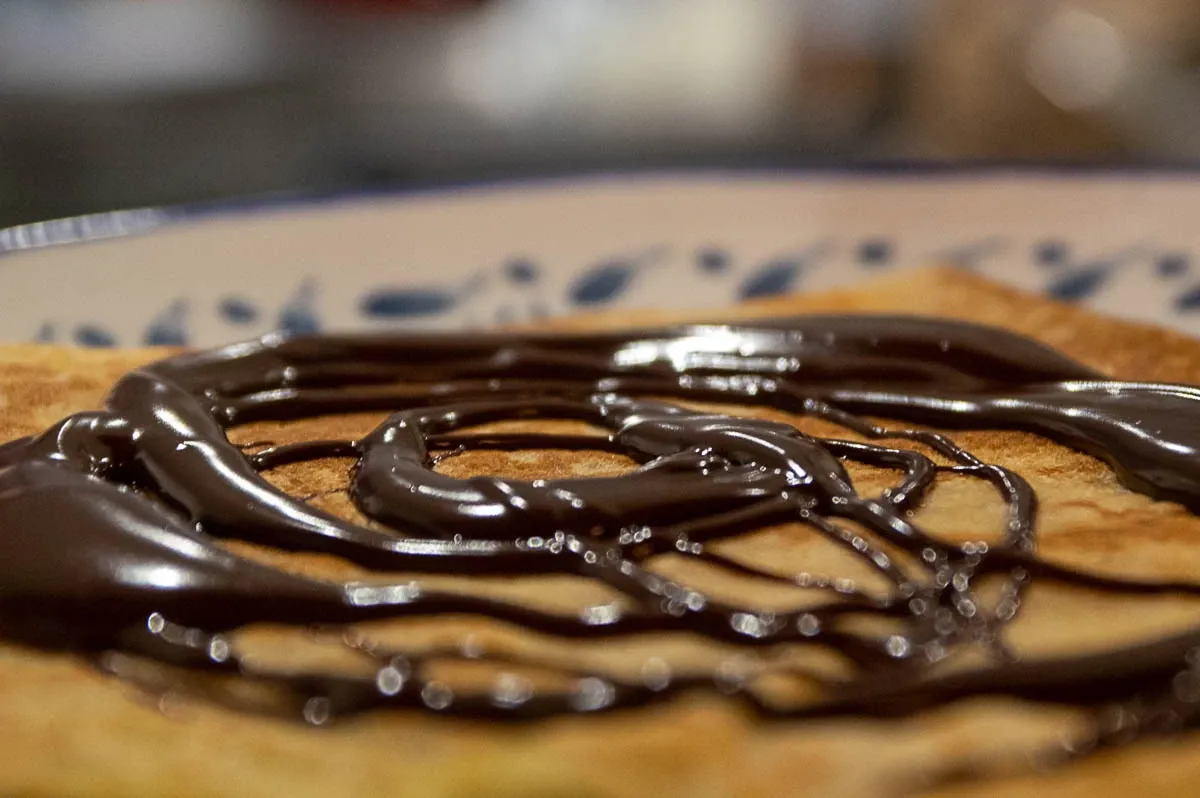 Gros plan sur une crêpe nappée de sauce chocolat